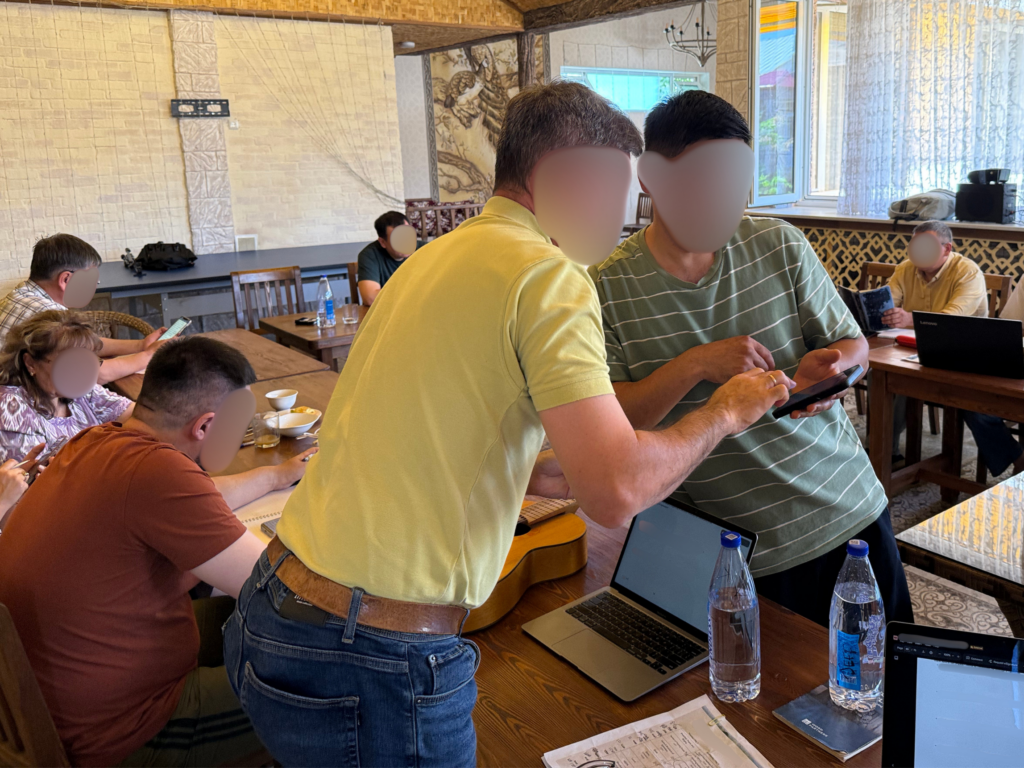 Pastors in Central Asia reading Scripture together on a phone